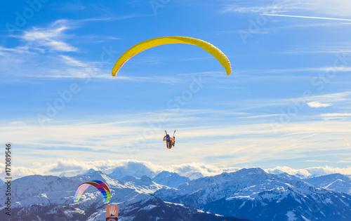 Paragliding over the mountains in winter. Ski resort Hopfgarten, Tyrol, Austria