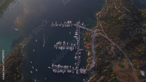 Aerial view of marina on sunrise/ Drone make a vertical flight over the yacht port