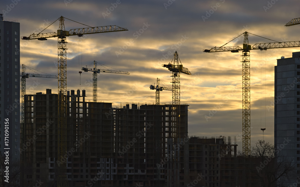 Cranes over new buildings in the early foggy morning. Cranes over new buildings in the early foggy morning.