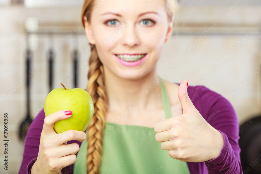 Woman young housewife in kitchen with apple fruit Woman young housewife in kitchen with apple fruit