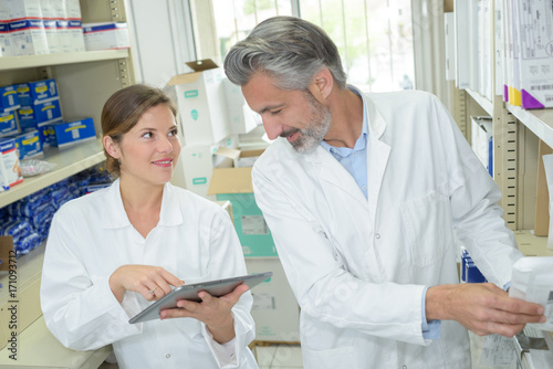 woman pointing at laptop screen when talking to pharmacist