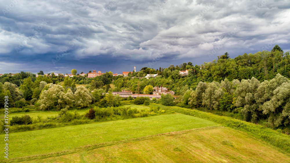 Dark heavy clouds warn of storm coming over field of Fagnano Olona in Italy.
