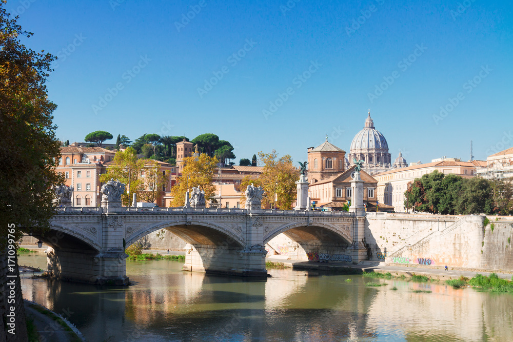 St. Peter's cathedral over bridge and Tiber river water in Rome, Italy