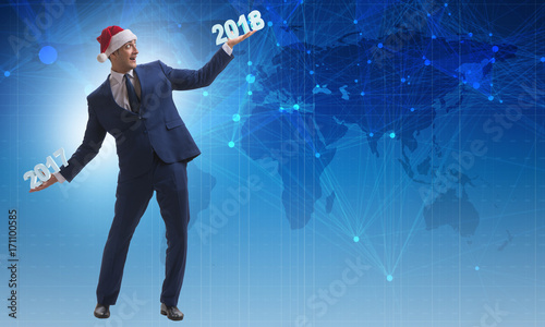 Businessman in santa hat holding 2017 and 2018