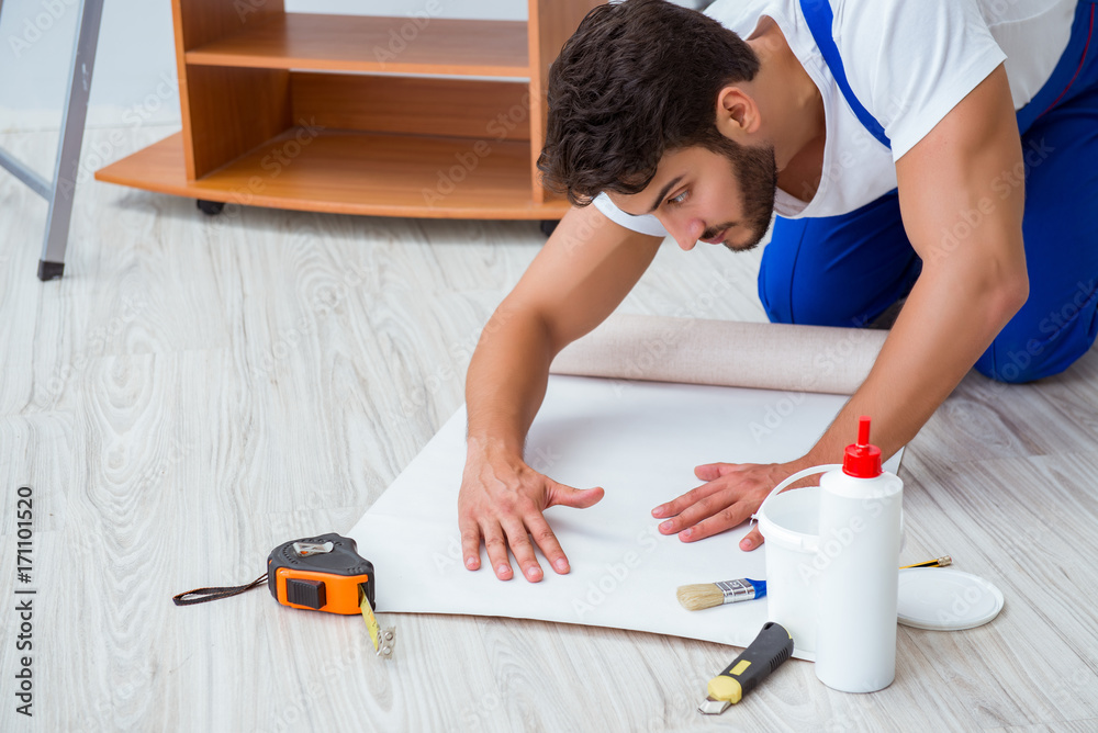Repairman doing renovation repair in the house with paper wallpa