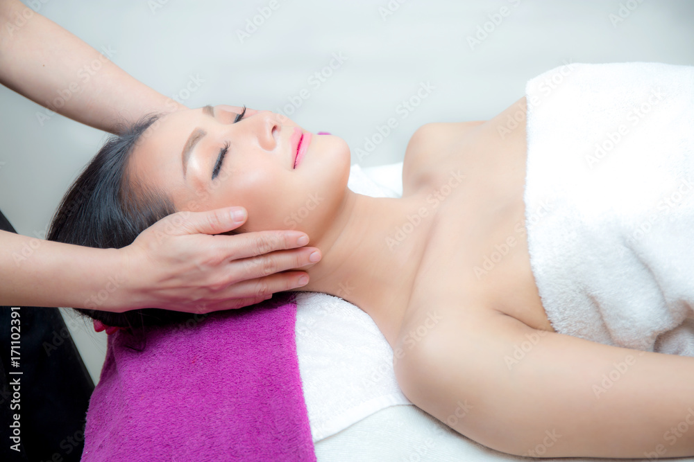 Beautiful woman is getting a facial massage in the spa salon