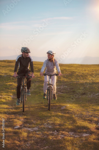 Happy mountainbike couple outdoors have fun together on a summer afternoon