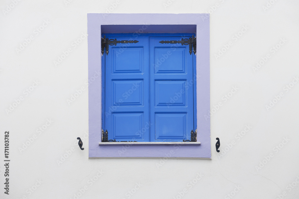 Blue window shutters and white wall Blue window shutters and white wall