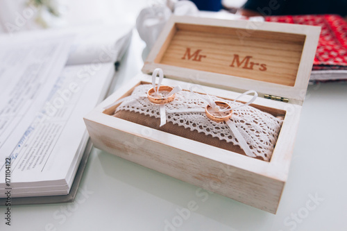 golden wedding rings in a white wooden box. Wedding decoration. Symbol of family, unity and love