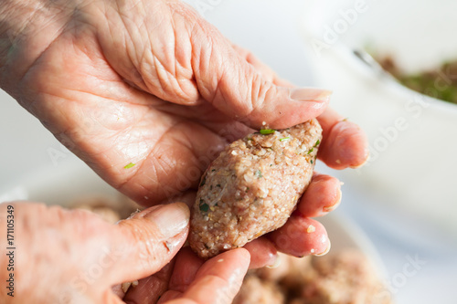 Step by step Levantine cuisine kibbeh preparation : Close up of a senior woman hands shaping a kibbeh