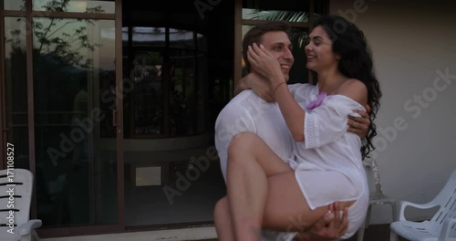 Happy Man Carry Woman Out On Terrace At Sunset, Romantic Couple In Love Kissing Over Tropical Landscape Slow Motion 60