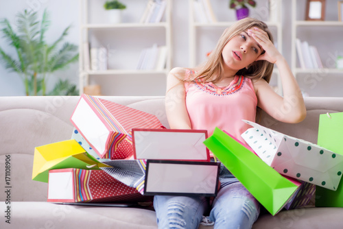 Bild auf Leinwand Young woman with shopping bags indoors home on sofa
