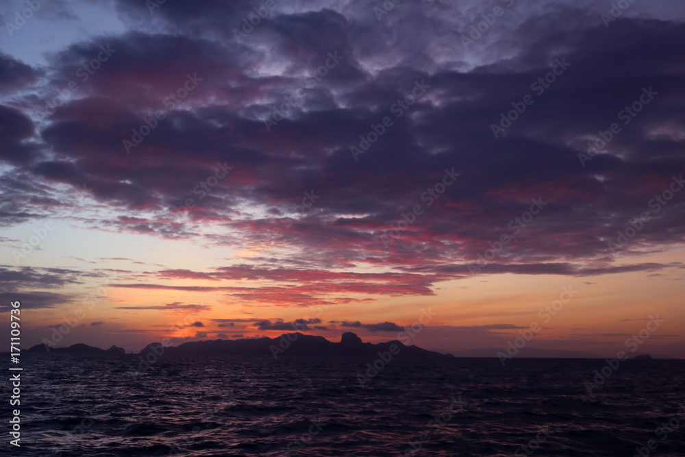 The clouds and purple red sky before sunrise in the ocean
