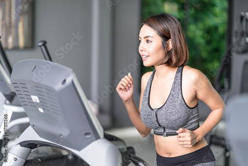 Young beautiful woman in sportswear working out in gym