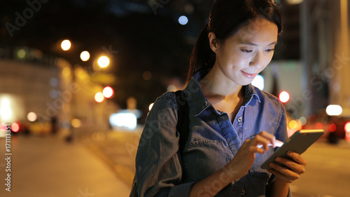 Canvas Print Woman use of mobile phone in the city at night