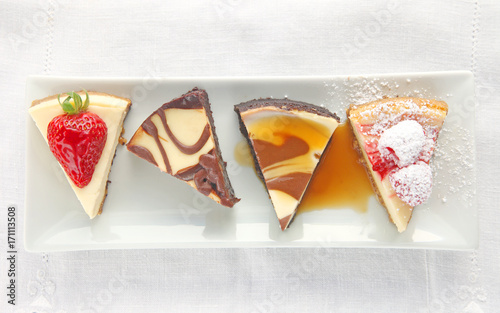 Four cheesecake portions topped with a choice of fresh berries, chocolate or caramel sauce