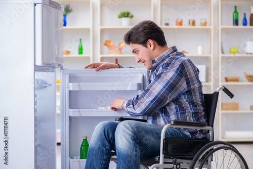 Young disabled injured man opening the fridge door  © Elnur