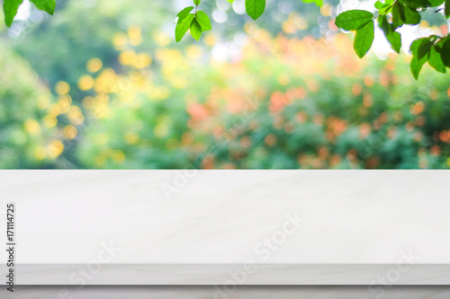 Fototapeta Naklejka Na Ścianę i Meble -  Empty white marble table over blur green park background, product display montage