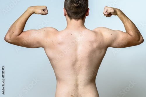 Fit muscular young man flexing his muscles