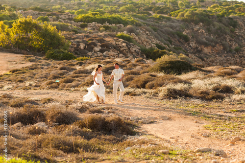 Bride and groom on a romantic moment on nature. Stylish wedding couple outdoors