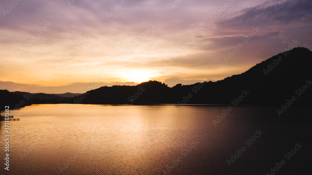Sunset landscape, silhouette mountains with lake