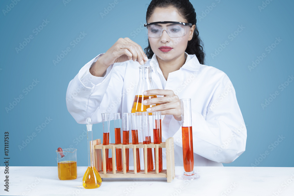 Researcher holds chemical liquid in test tube Researcher holds chemical liquid in test tube