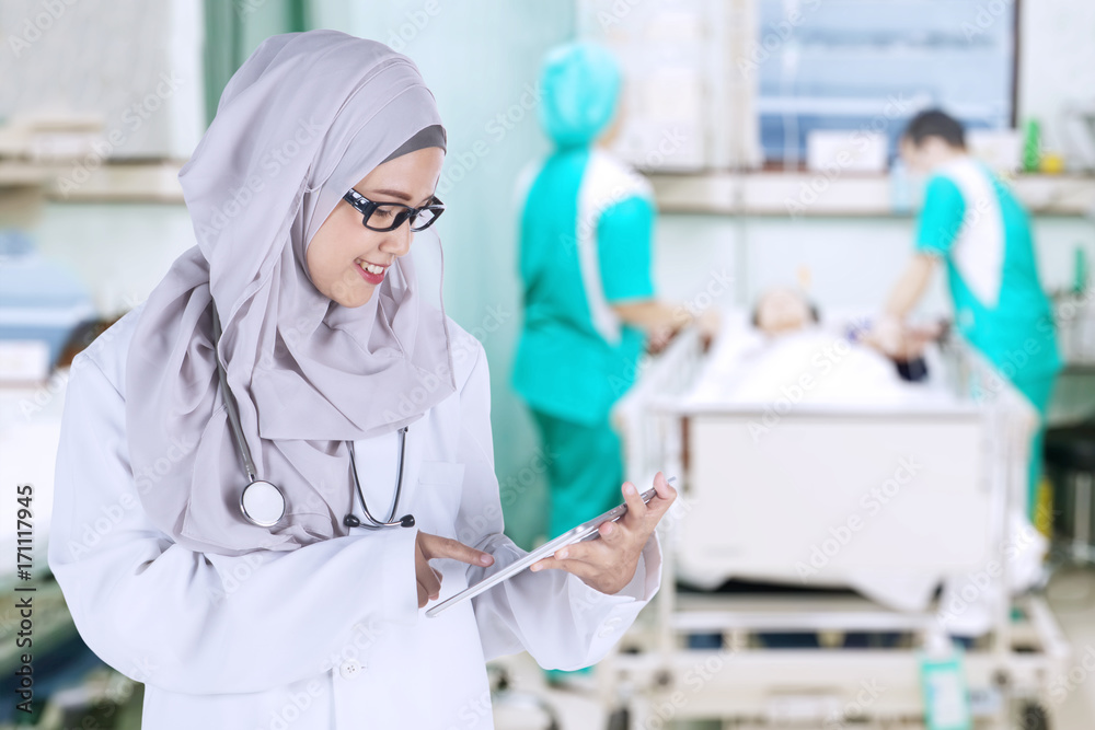 Muslim doctor is working with a digital tablet Muslim doctor is working with a digital tablet