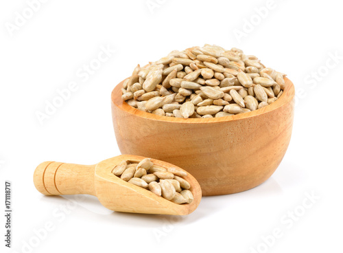 Unpeeled sunflower seeds in wooden bowl isolated on white background, fresh hulled sunflower seeds in wooden spoon