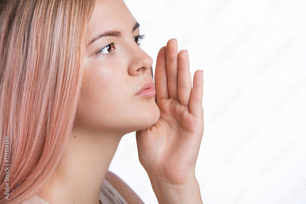 Portrait of young gossip girl holding hand near face and telling secret Portrait of young gossip girl holding hand near face and telling secret