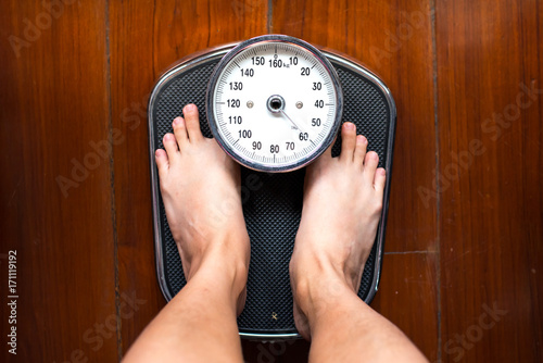 The feet standing on weighing apparatus.