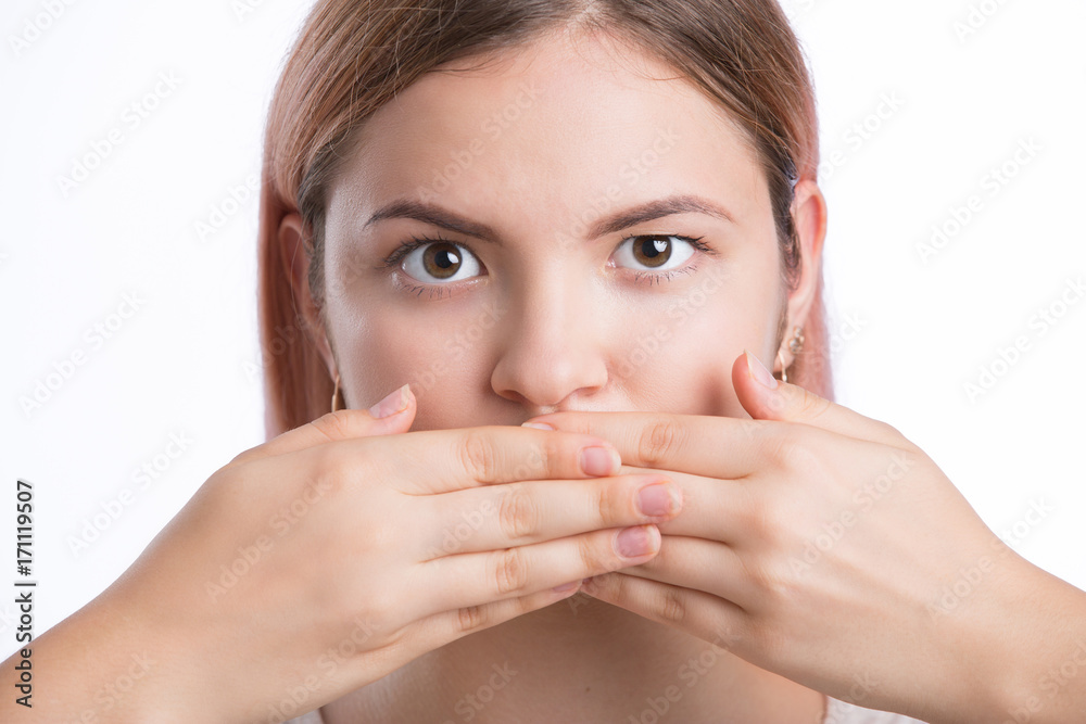 Young cute woman covering her mouth with a hand. concept for silence Young cute woman covering her mouth with a hand. concept for silence