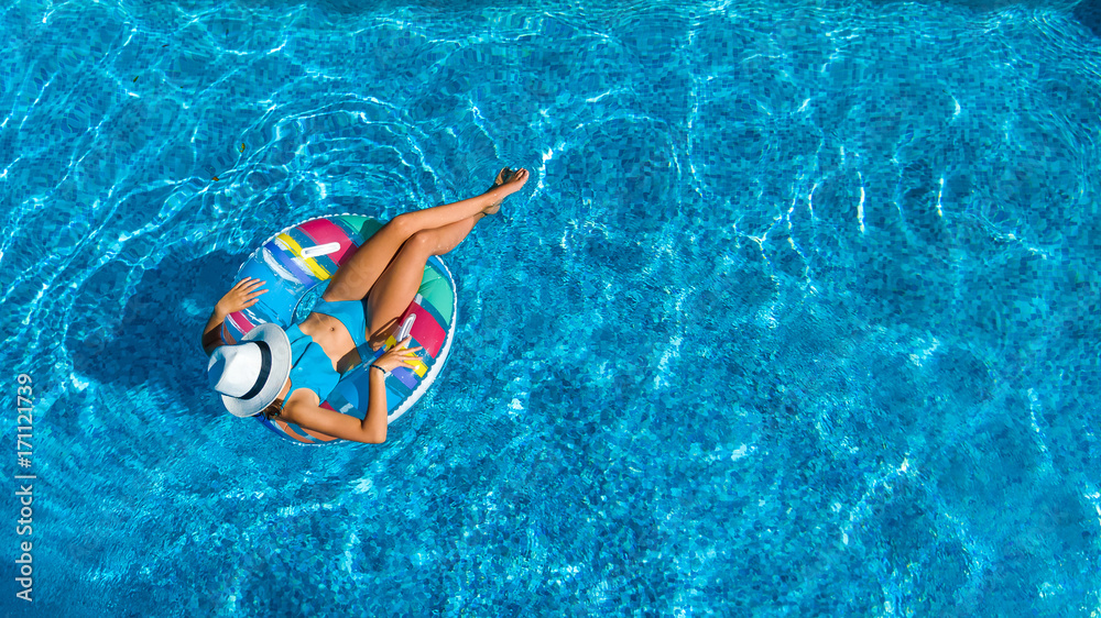 Aerial top view of beautiful girl in swimming pool from above, relax ...