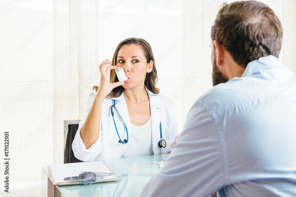 Doctor inhales an aerosol inhaler on a demonstration Doctor inhales an aerosol inhaler on a demonstration