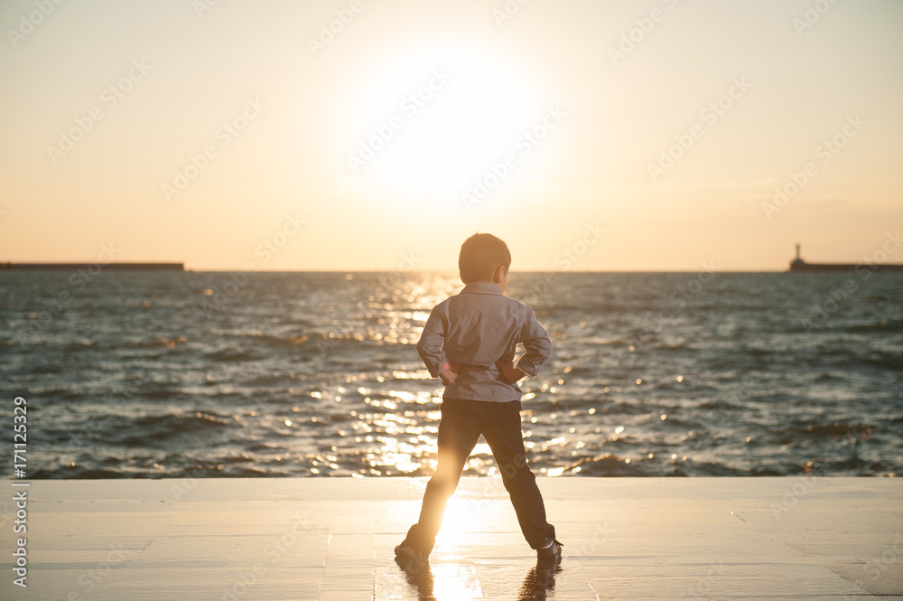 confident kid on the background of beautiful sea sunset confident kid on the background of beautiful sea sunset