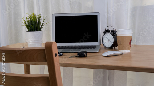 Laptop with smart phone notebook and coffee cup on workplace table. © pixindy