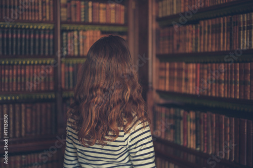 Woman looking at books in an old library