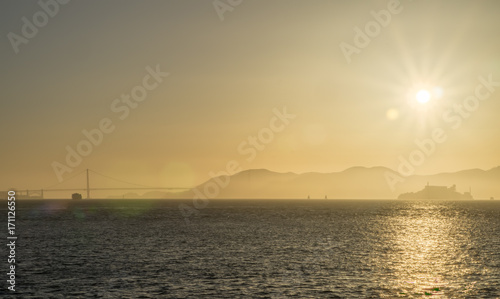 golden sunset over golden gate bridge and alcatraz in san francisco