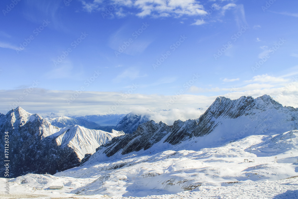 View of a mountain range with snow and clouds