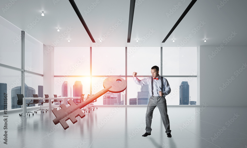 Fototapeta premium Breaking through access concept with furious man crashing concrete key