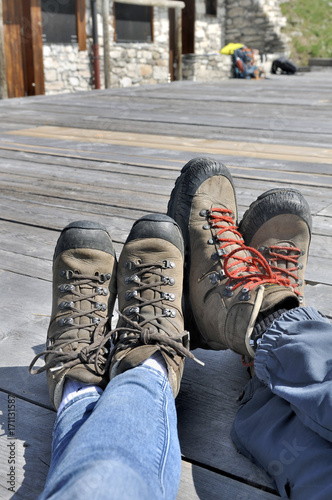 pieds d'un couple en chaussures de randonnée  sur terrasse bois