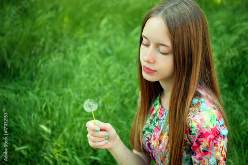 Girl blowing on a dandelion.