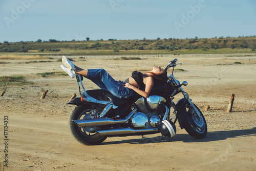 beautiful young redhead woman in bikini on motorcycle