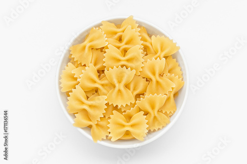 Pasta farfalle close-up in white bowl, white background photo