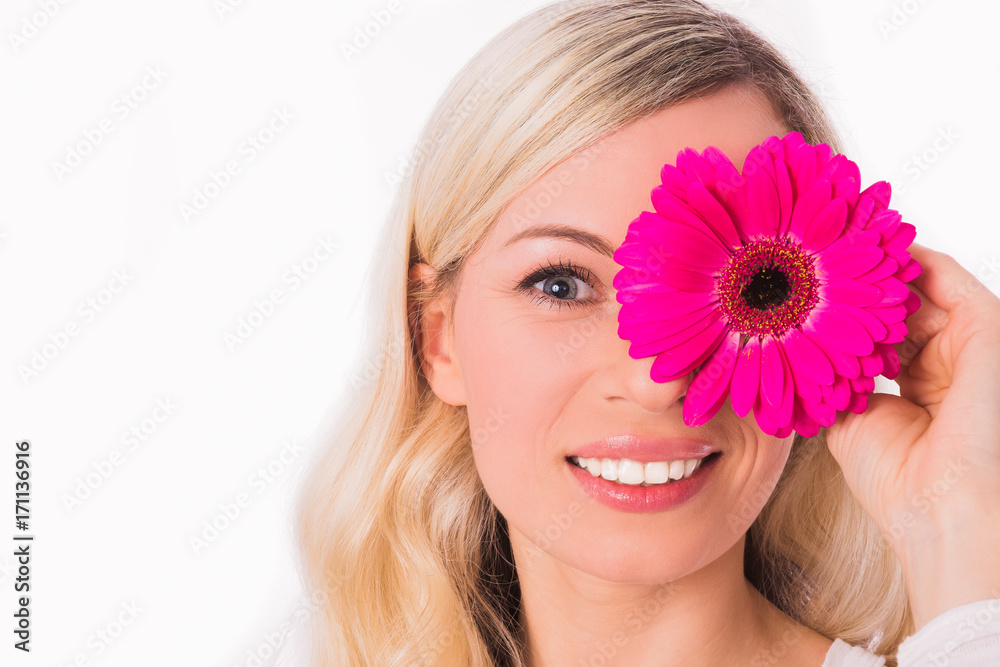 Close-up face of young beautiful blonde woman who keeping rose flower on an eye against the white background