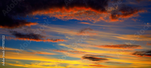 Photo of orange sunset with dark clouds on sky