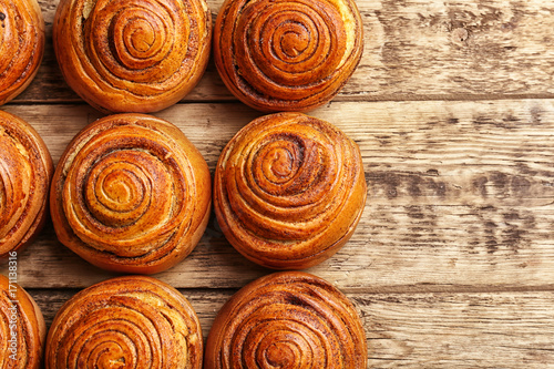 Sweet cinnamon rolls on wooden table