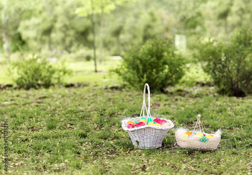 Fototapeta Naklejka Na Ścianę i Meble -  Baskets with colorful eggs on green grass in park. Easter hunt concept