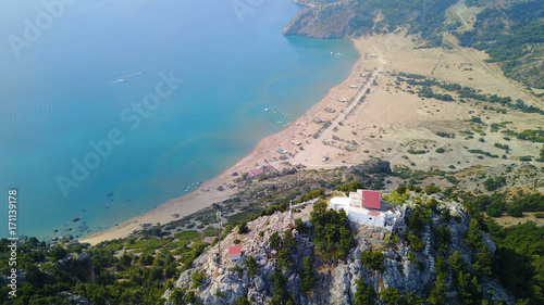 August 2017: Aerial drone photo of famous Tsabika monastery overlooking iconic Tsabika bay from the cliff with clear turquoise waters, Rhodes island, Aegean, Dodecanese, Greece photo