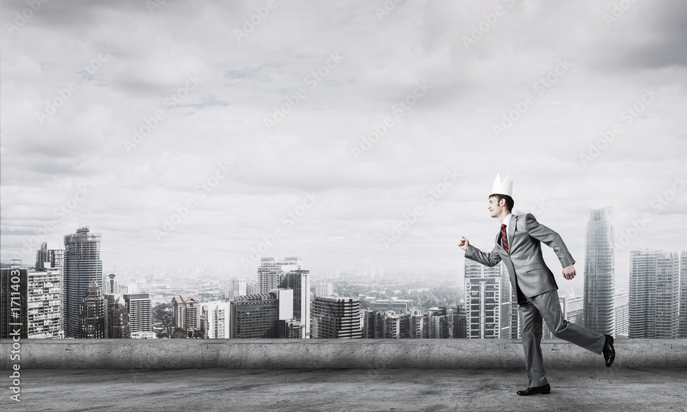 King businessman in elegant suit running on building roof and bu King businessman in elegant suit running on building roof and bu
