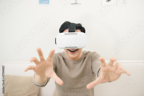 Asian young man watch a movie using vr device glass